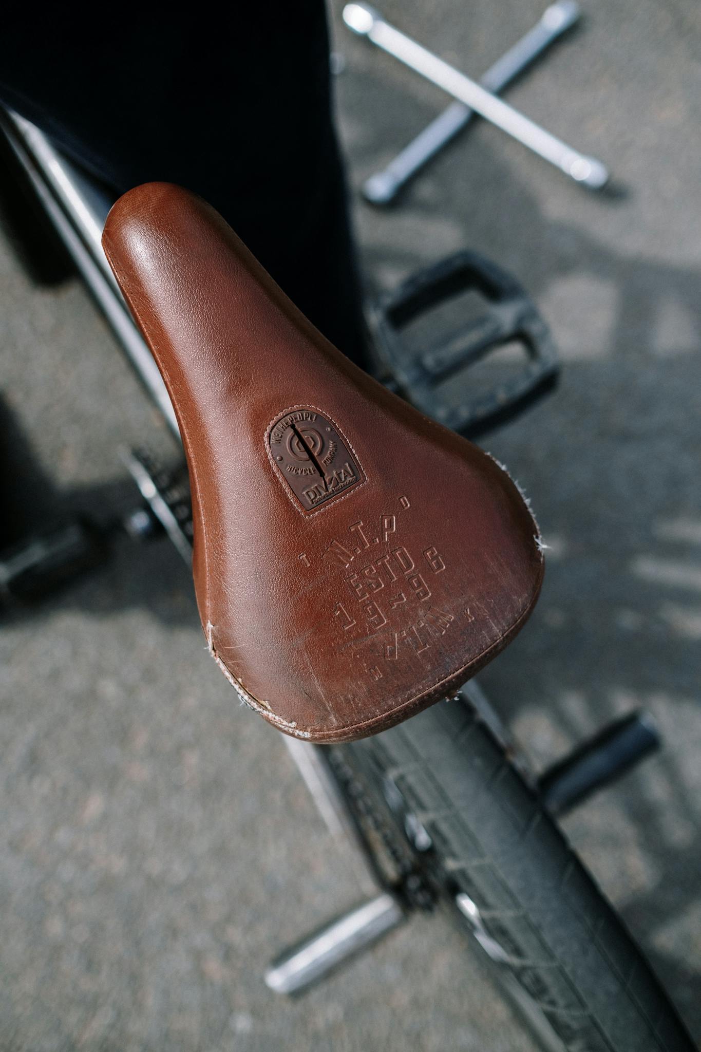 Aerial view of a brown leather bicycle seat with bike repair tools.